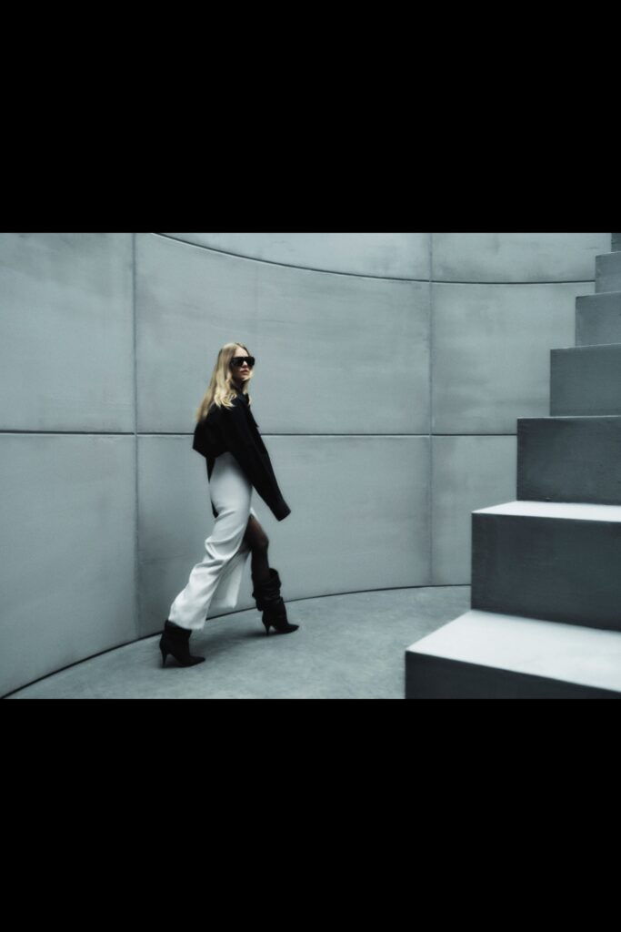 A fitted black and white outfit featuring a long-sleeve jacket and asymmetric pants.