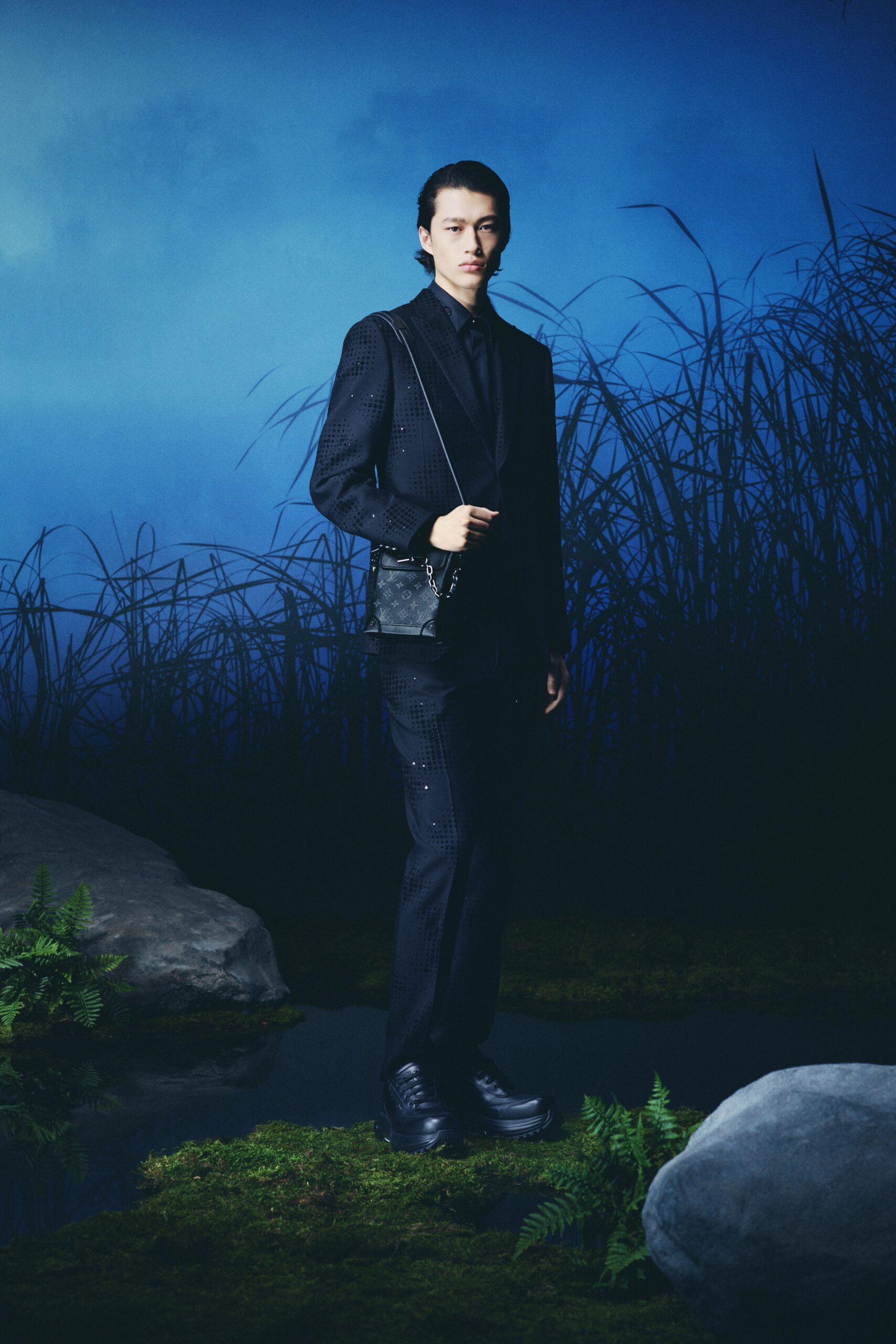 A fitted black cotton suit with long sleeves and a collared design, featuring buttoned details.