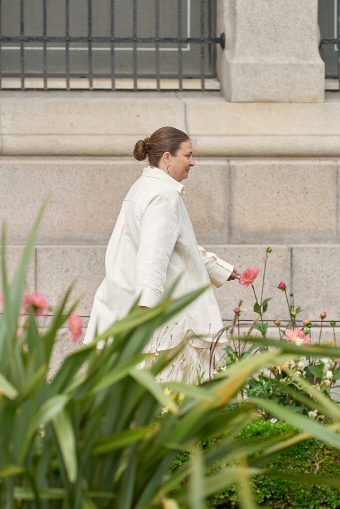 A relaxed white cotton coat with long sleeves and a collared design, featuring button details.
