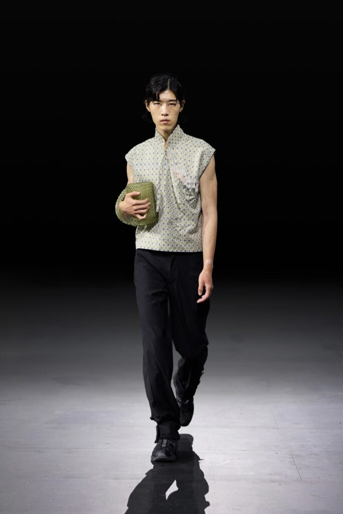 A tailored sleeveless white cotton shirt paired with black pants for a modern look.