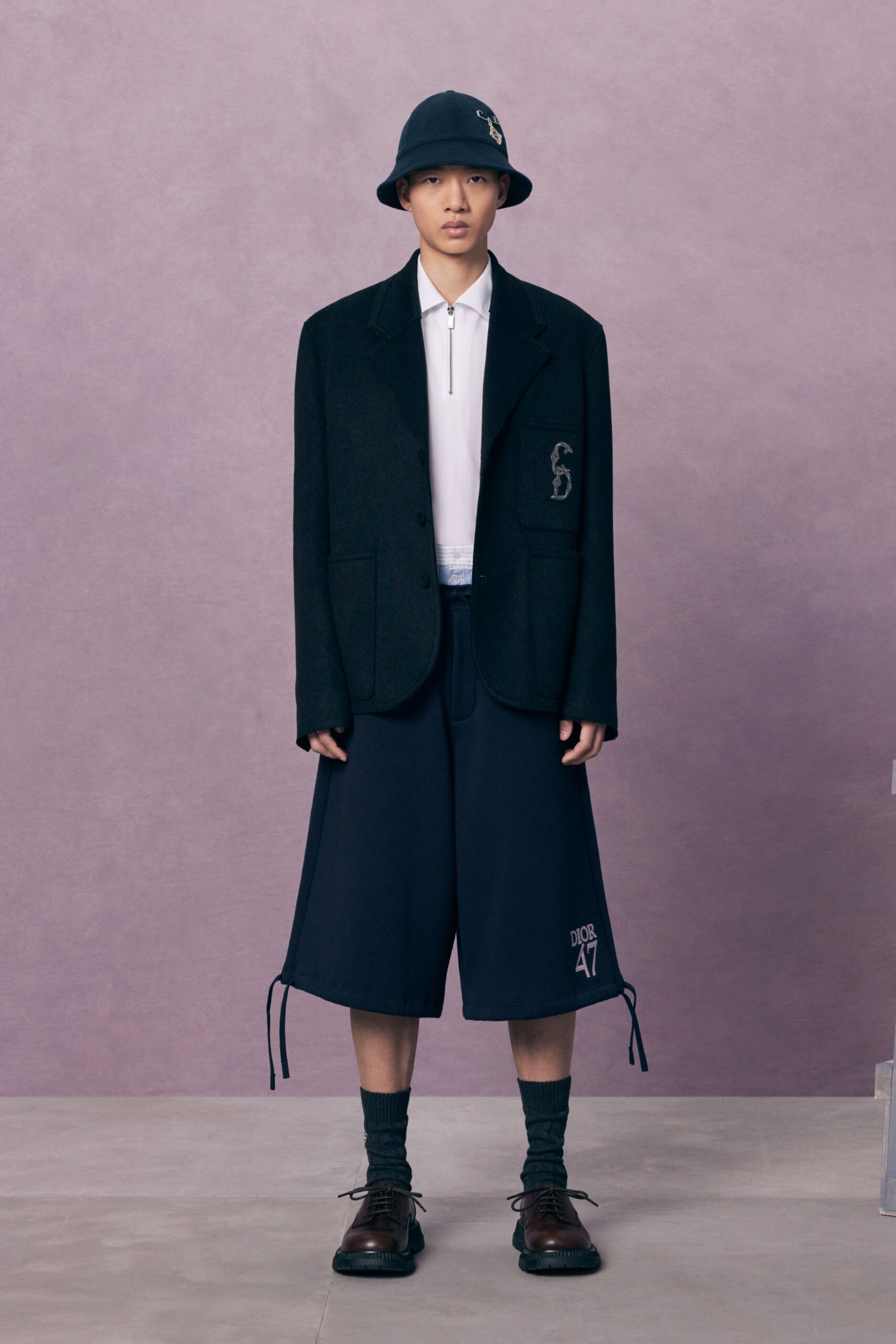 An oversized black jacket paired with navy shorts, creating a modern and stylish look.