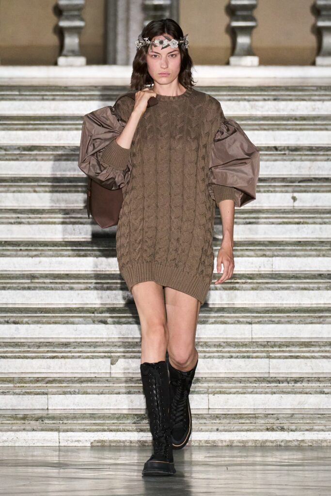 A relaxed brown knit dress with long sleeves and a crew neckline.
