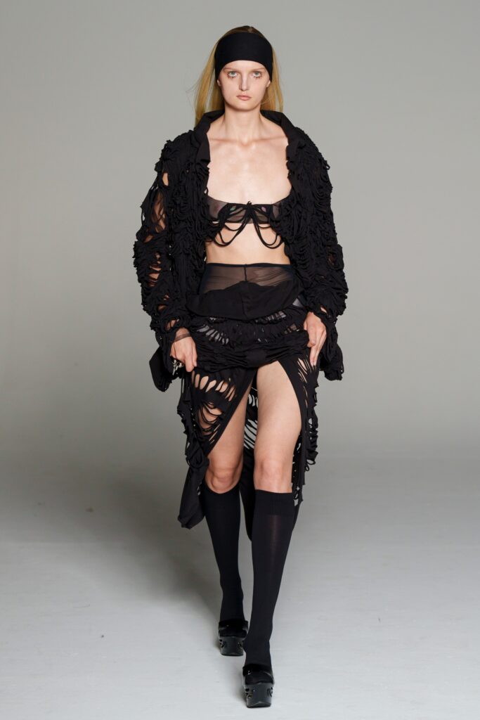 black fitted top and skirt with oversized coat