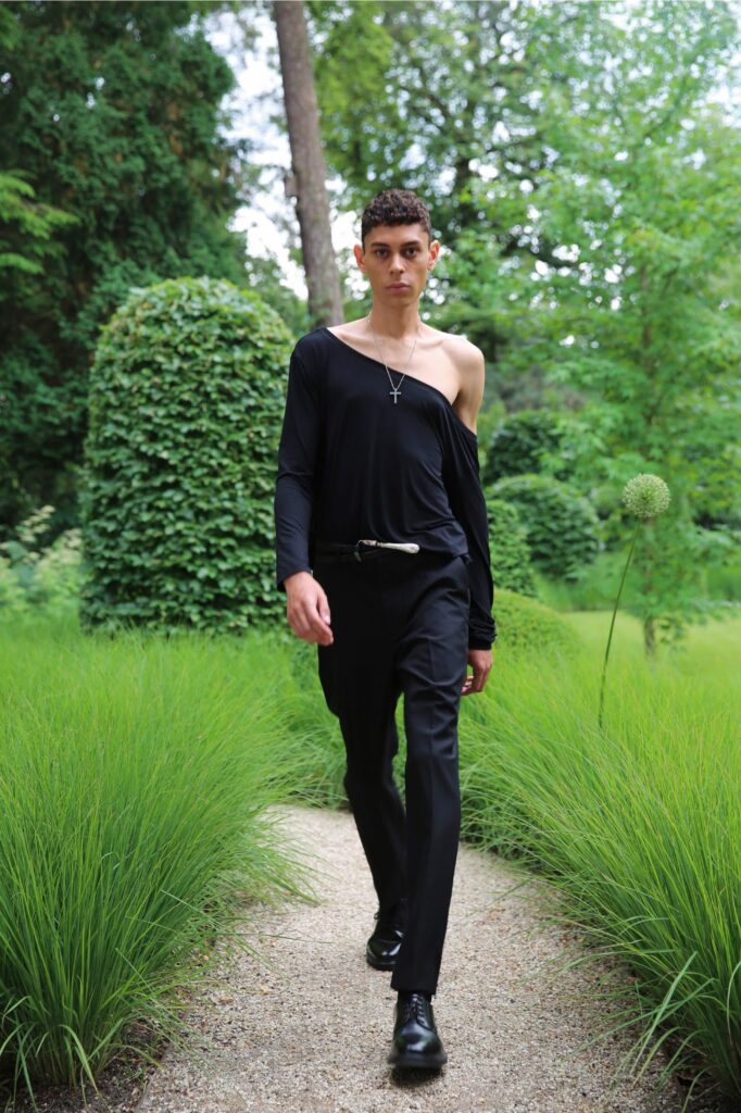 A fitted black off-shoulder shirt paired with straight-leg pants for a modern look.
