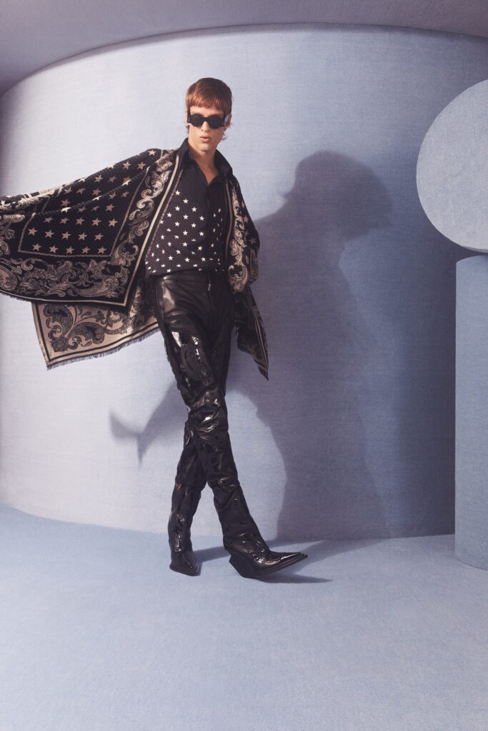 A stylish ensemble featuring fitted black leather pants paired with a long-sleeve black and white blouse.
