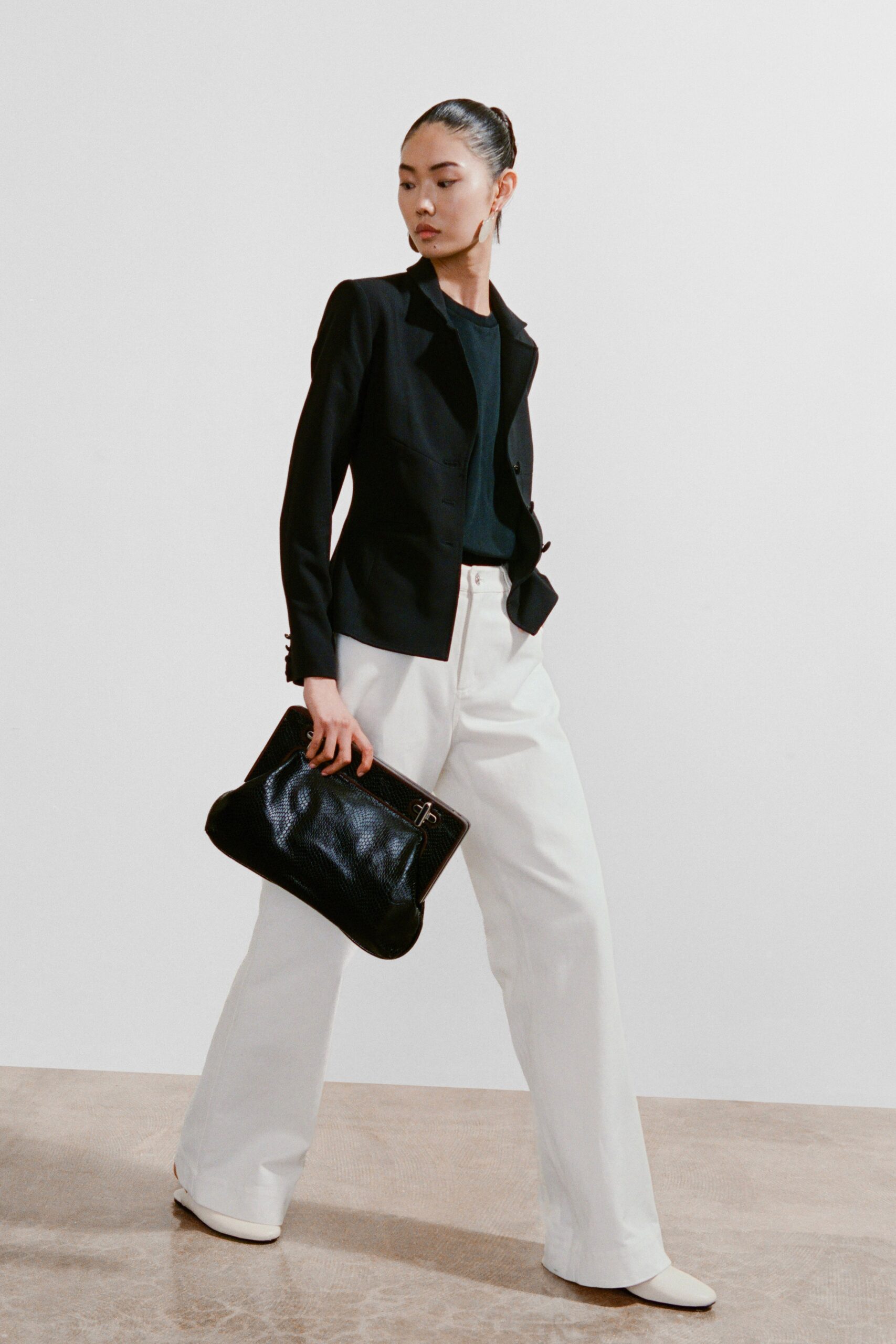 A fitted black blazer paired with straight-leg white pants, creating a chic and modern look.
