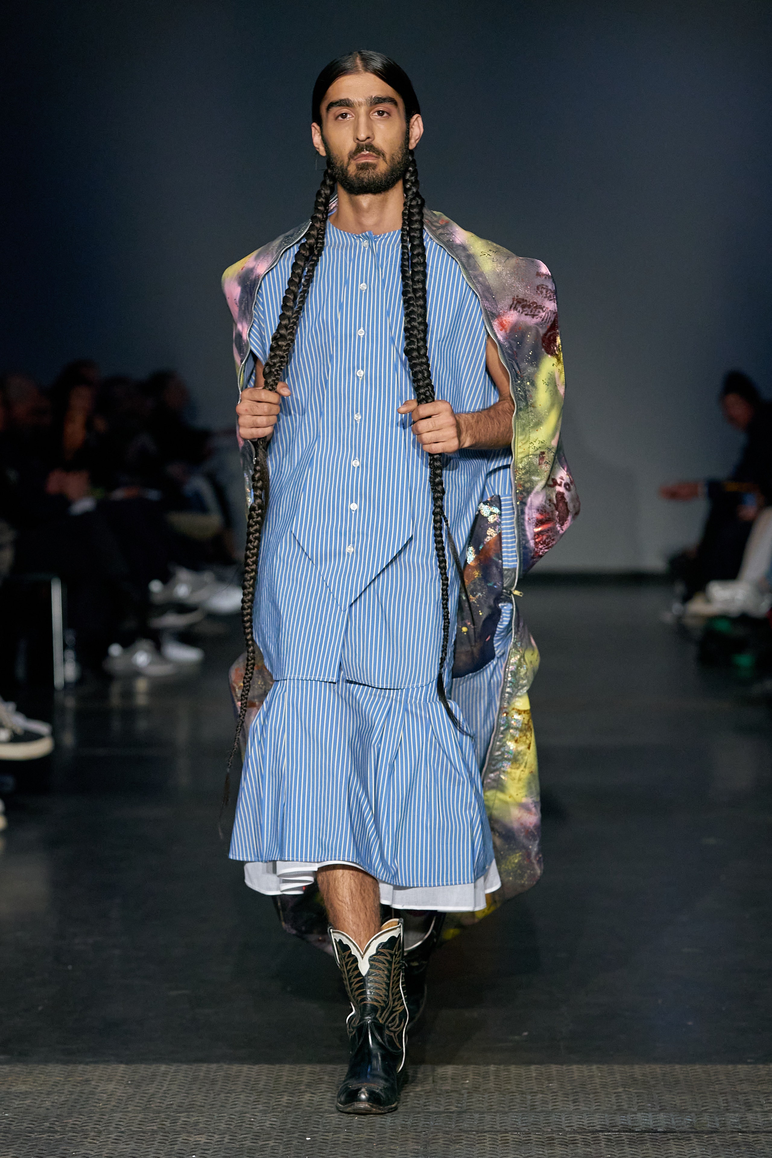 A relaxed blue striped dress layered with a multicolor cape and long sleeves.