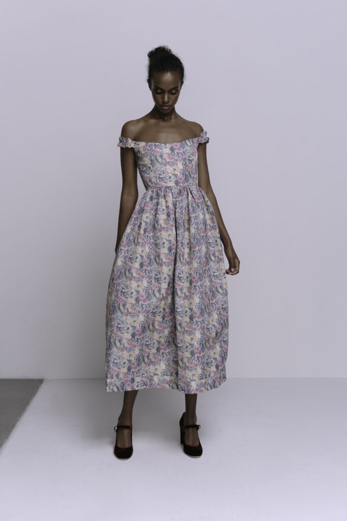 A relaxed multicolor cotton dress with an off-shoulder design and tiered silhouette.
