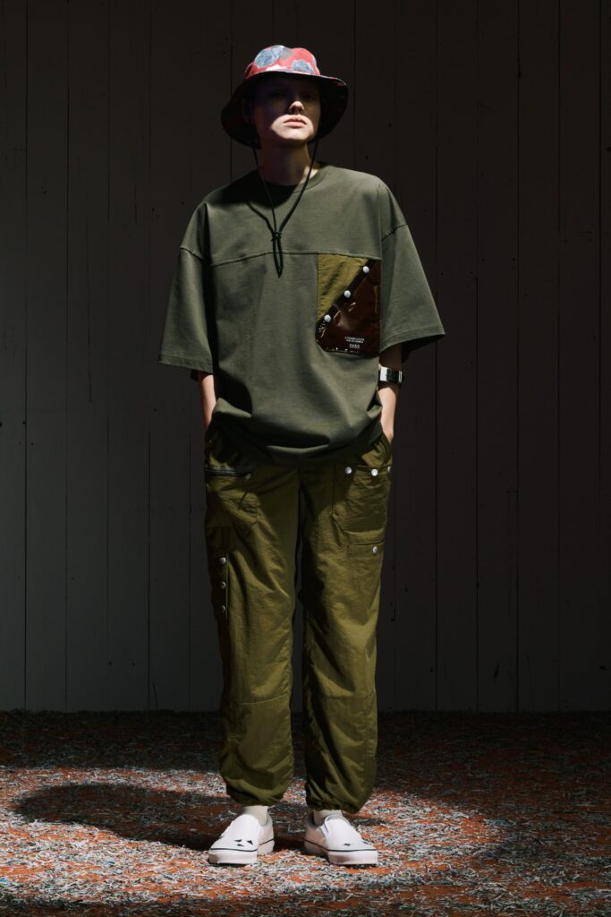 A relaxed green shirt with short sleeves paired with high-waisted pants featuring pockets.
