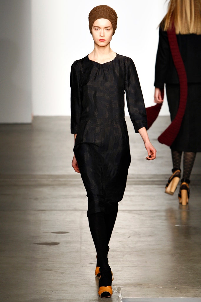 A relaxed black silk dress with long sleeves and an asymmetric design detail.