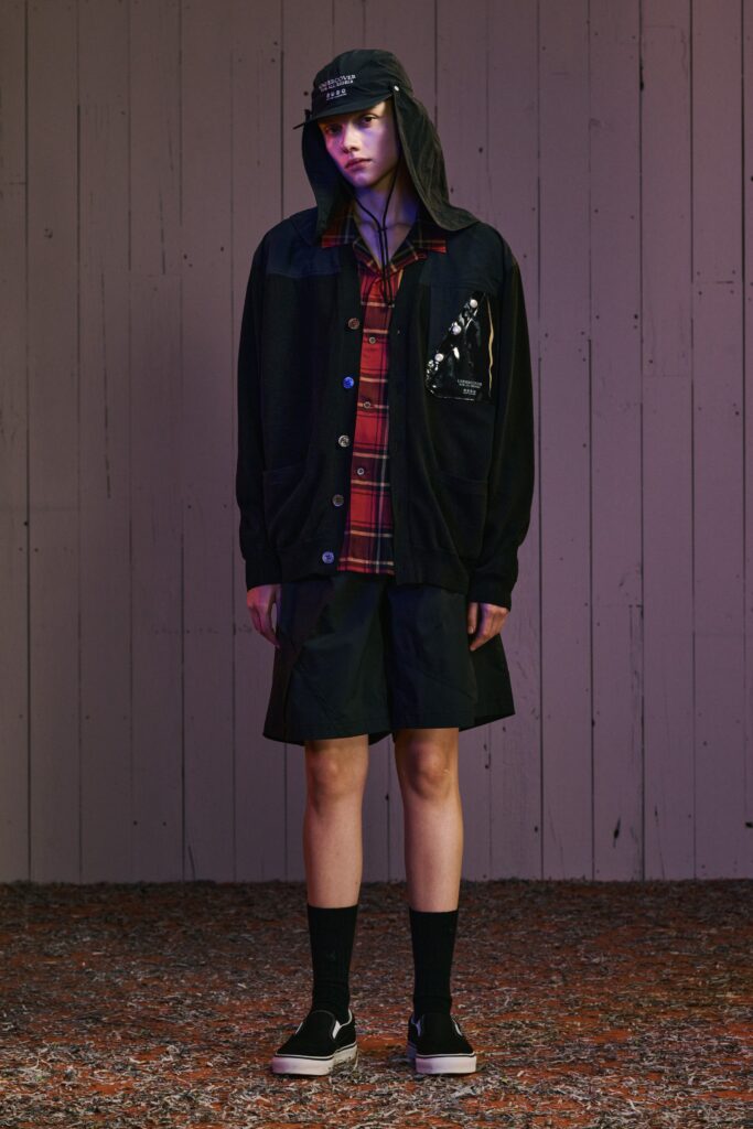 A relaxed black jacket with long sleeves and a collared design paired with a high-waisted skirt.