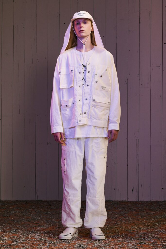A relaxed white jacket with long sleeves and pants featuring buttoned and pocketed details.