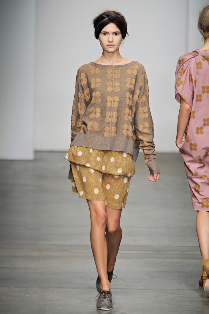 A relaxed brown printed sweater paired with a beige printed skirt for a casual look.