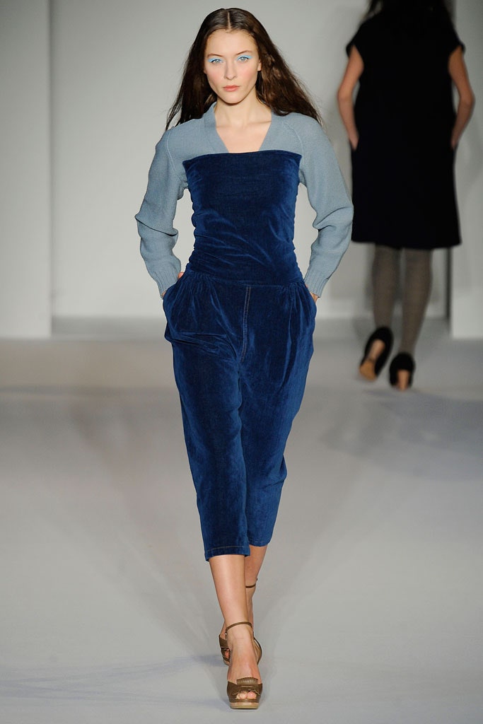A fitted blue velvet jumpsuit with long sleeves and a V-neckline featuring a straight-leg silhouette.