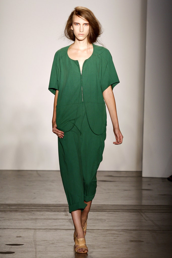A relaxed green cotton jumpsuit with short sleeves and a collared neckline.