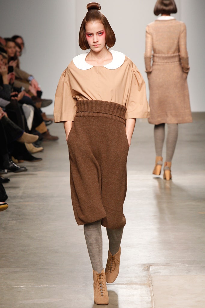 A relaxed beige and brown dress with short sleeves, a collared neckline, and pleated asymmetric design.