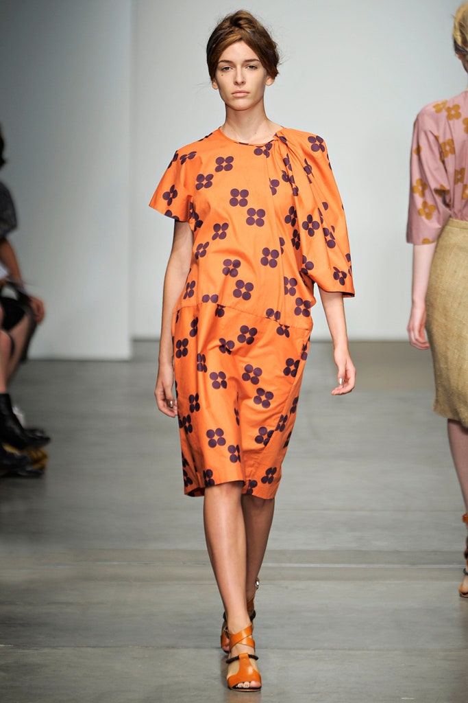 A relaxed orange dress with short sleeves and a floral print design.
