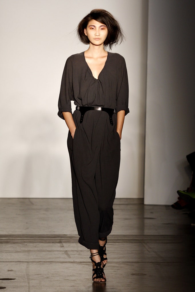 A relaxed black cotton jumpsuit with a V-neckline and zippered detail.
