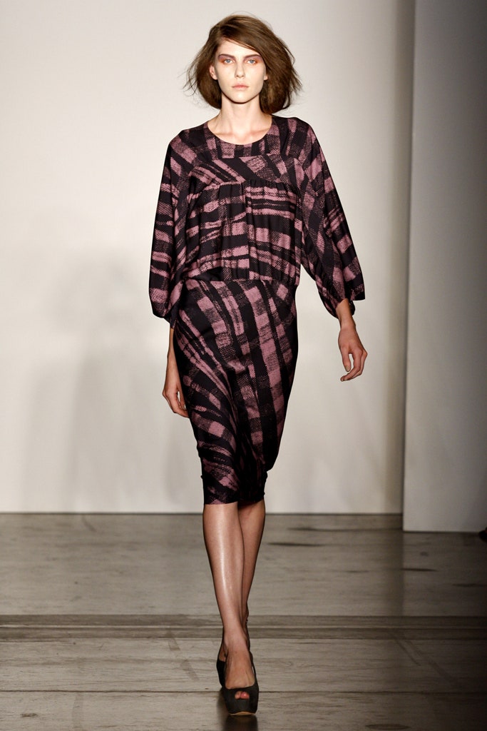 A fitted black and pink printed dress with long sleeves and a V-neckline.