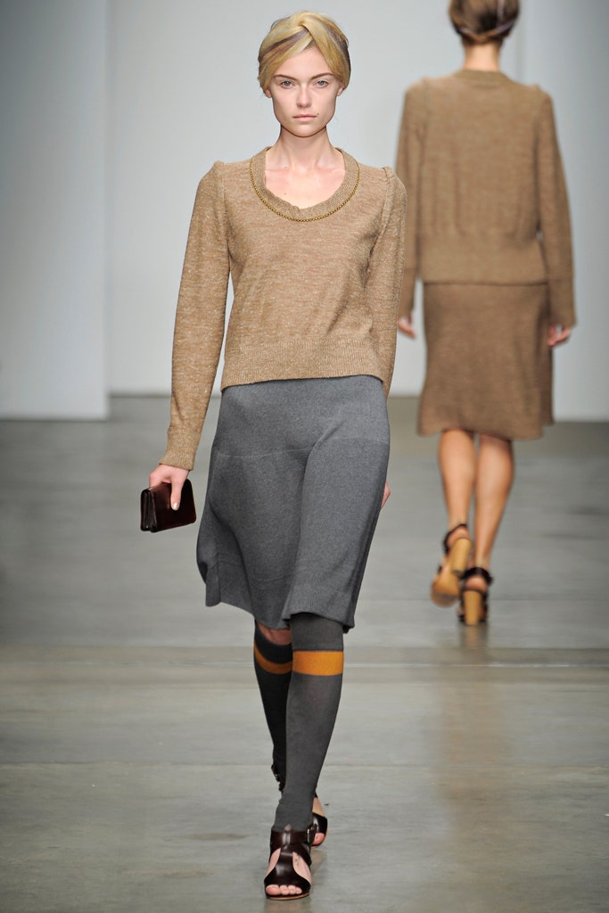 A fitted gray wool dress with a scoop neckline and asymmetric design detail.
