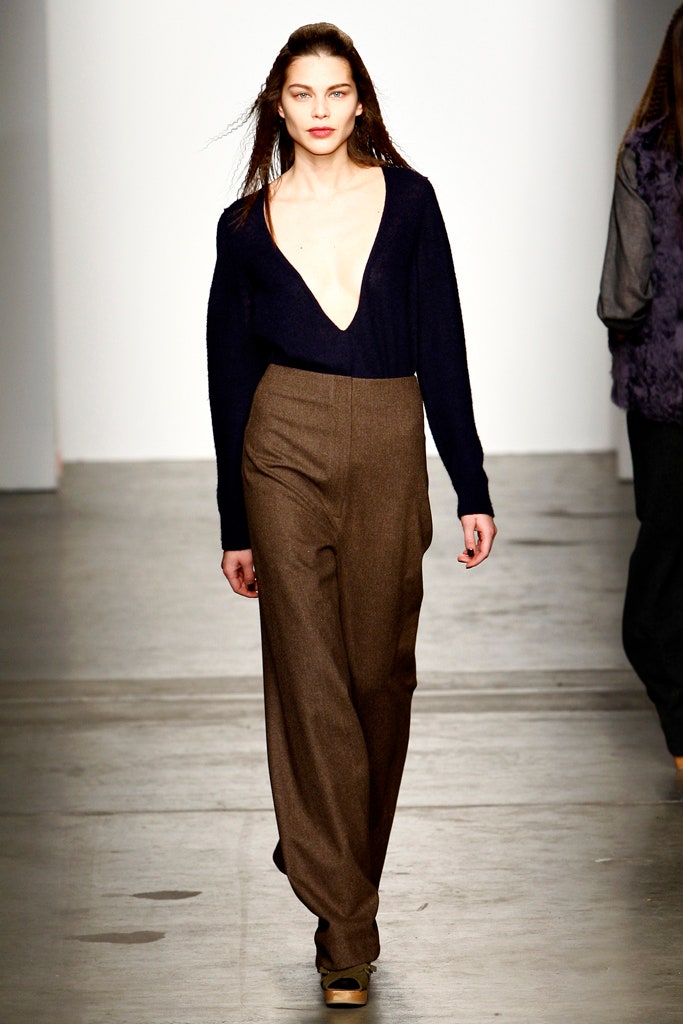 A relaxed navy wool long-sleeve top with a V-neck paired with wide-leg brown pants.