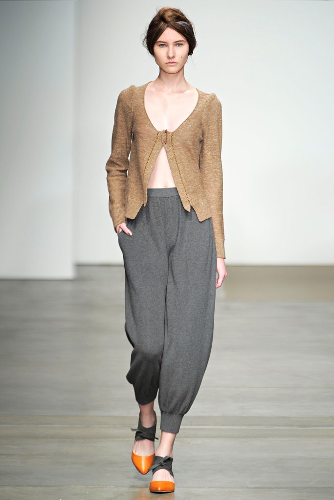 A relaxed beige cardigan with a V-neckline paired with gray relaxed pants.