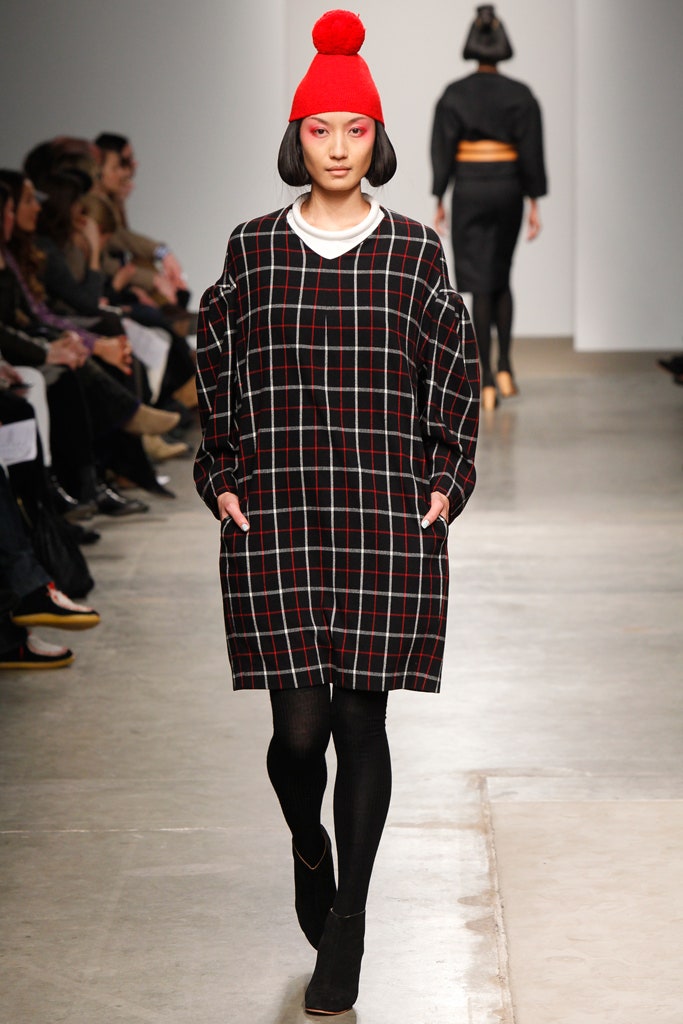 An oversized black checked dress with long sleeves and a collared neckline.