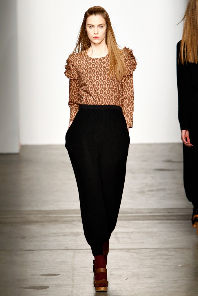 A relaxed brown printed long-sleeve top paired with relaxed black wide-leg pants.