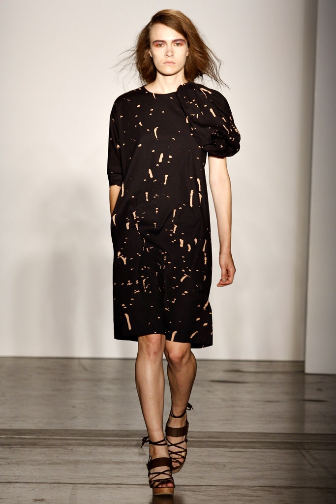 A relaxed black dress with short sleeves and an asymmetric design detail.