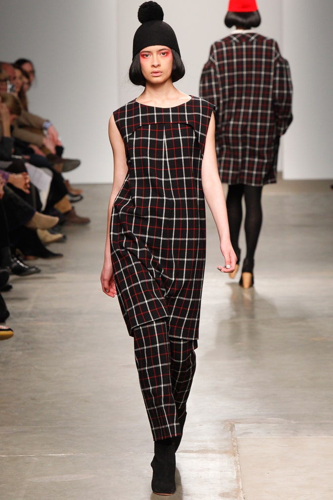 A relaxed sleeveless jumpsuit in a black, red, and white checked pattern.