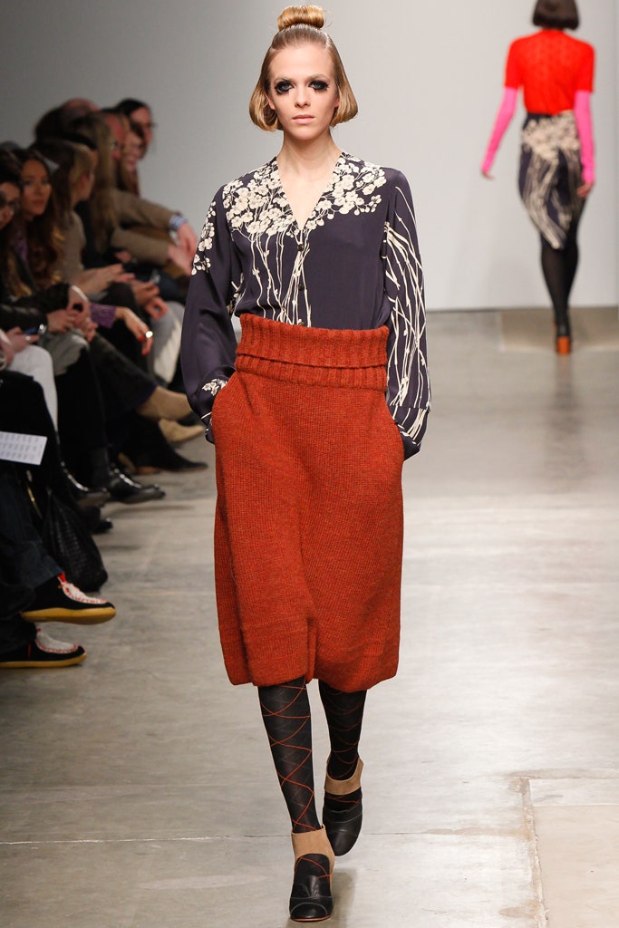A relaxed fit blue printed blouse paired with a pleated orange skirt.