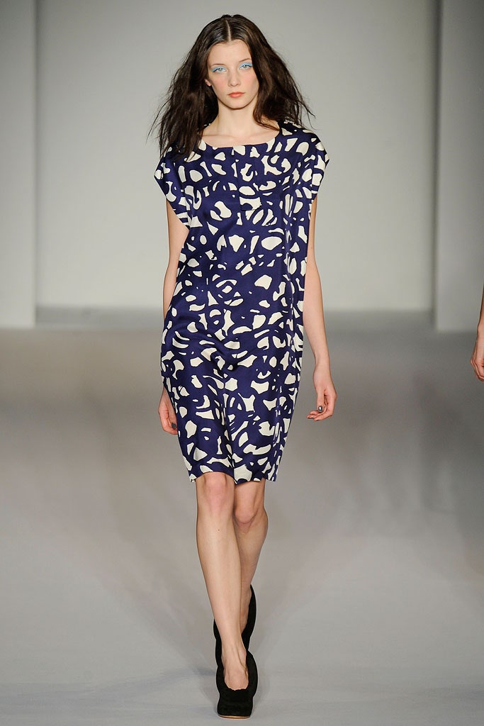A fitted blue dress with short sleeves and a round neckline featuring a unique print.
