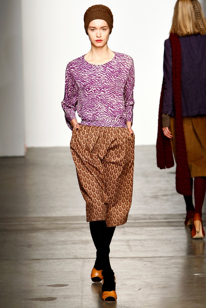 A relaxed long-sleeve purple printed top paired with relaxed brown patterned pants.