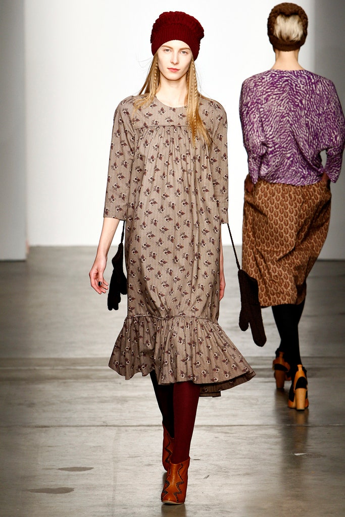 A relaxed brown cotton dress with long sleeves and a tiered design.