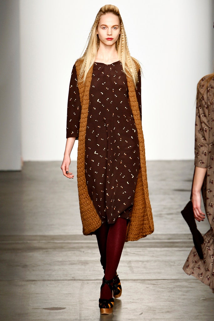 A relaxed brown printed dress layered with a beige coat featuring long sleeves.