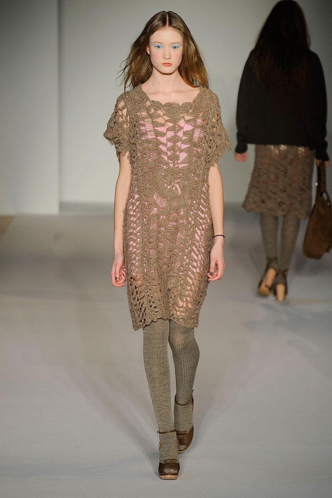 A relaxed beige crochet sleeveless dress with a round neckline and tiered design.