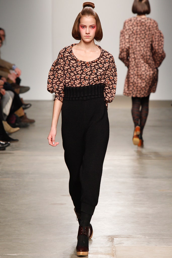 A relaxed black jumpsuit with long sleeves and a multicolor floral print design.