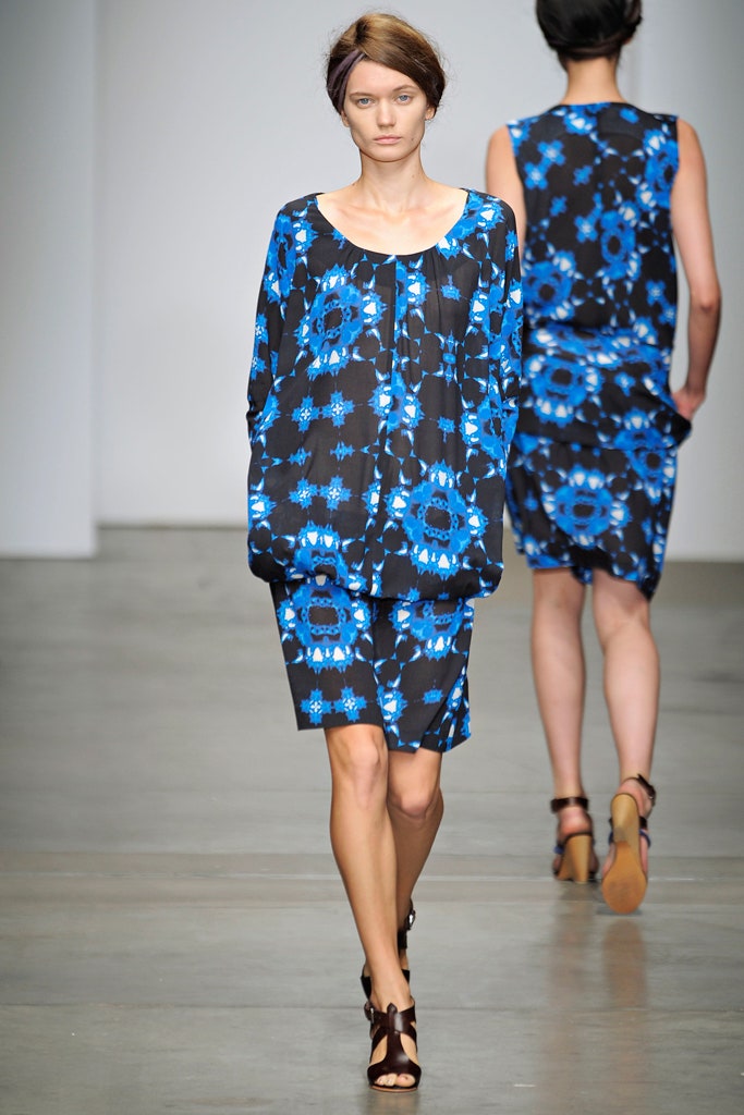 A relaxed blue dress with long sleeves, a collared neckline, and a vibrant printed design.