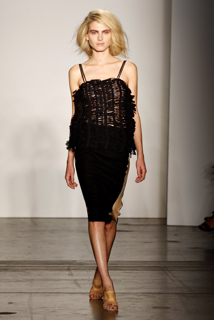 A fitted black sleeveless dress with a V-neckline and asymmetric design detail.