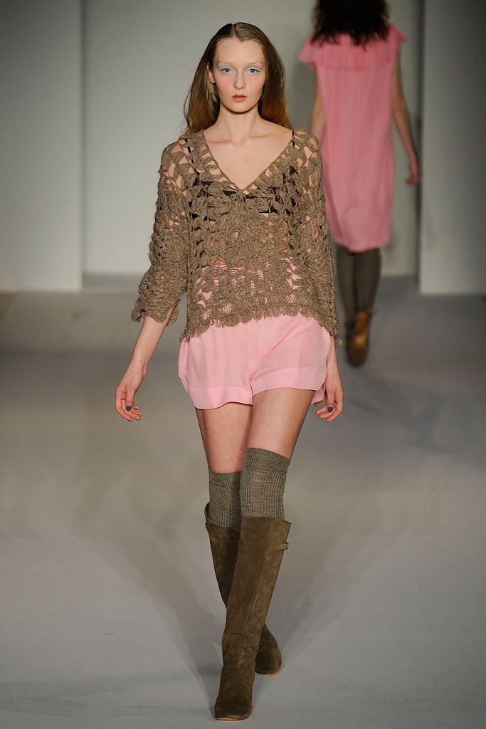 A relaxed brown knit sleeveless top paired with pink shorts for a casual look.
