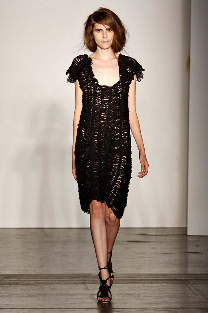 A fitted black sleeveless dress with a V-neckline and layered design.