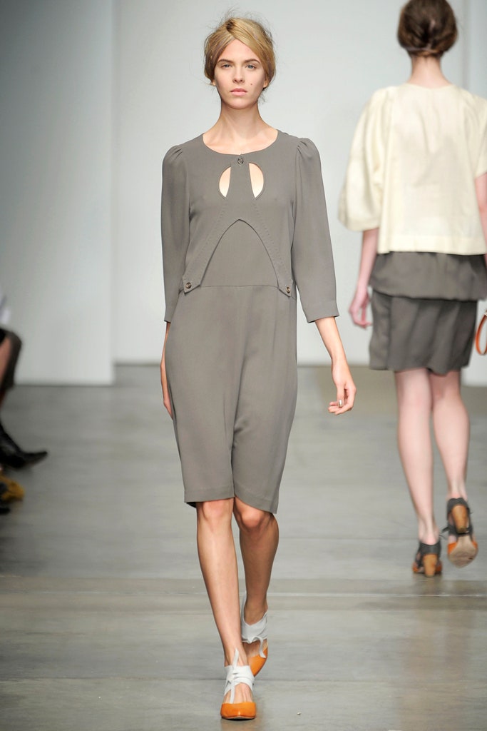 A fitted gray dress with three-quarter sleeves and an asymmetric design detail.