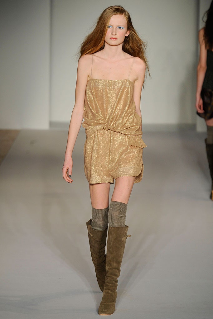 A fitted gold silk sleeveless dress with a V-neckline and draped design.