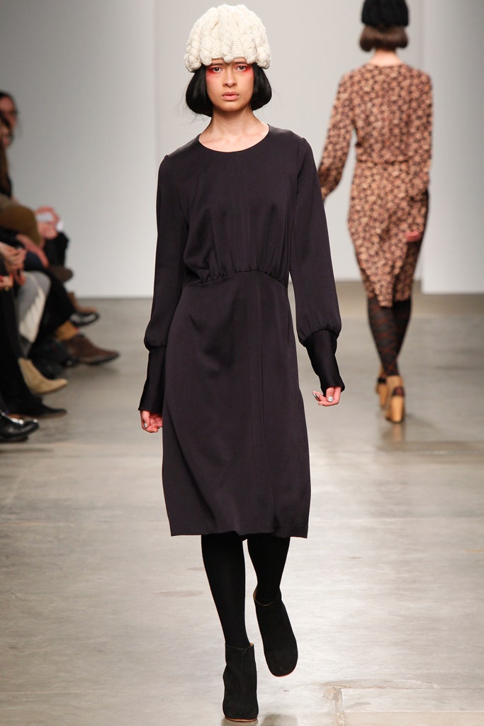 A relaxed black long-sleeve dress with a collared neckline and straight-leg silhouette.