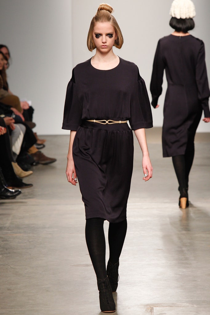 A relaxed black dress with short sleeves and a belted waist for a stylish silhouette.