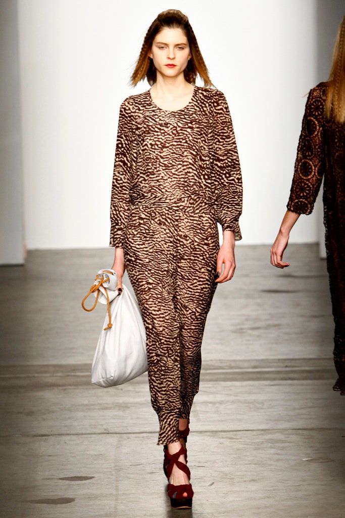A relaxed brown printed jumpsuit with long sleeves and a collared neckline.
