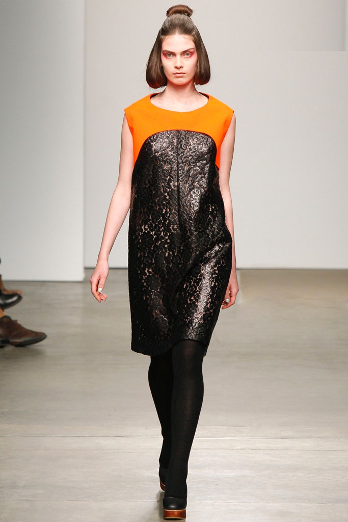 A relaxed black and orange sleeveless dress with a high neckline and asymmetric design.