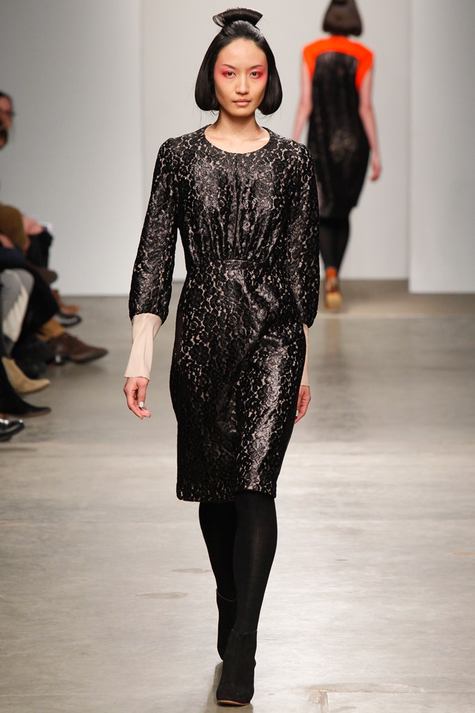 A fitted black silk dress with long sleeves and a high neckline featuring a printed design.