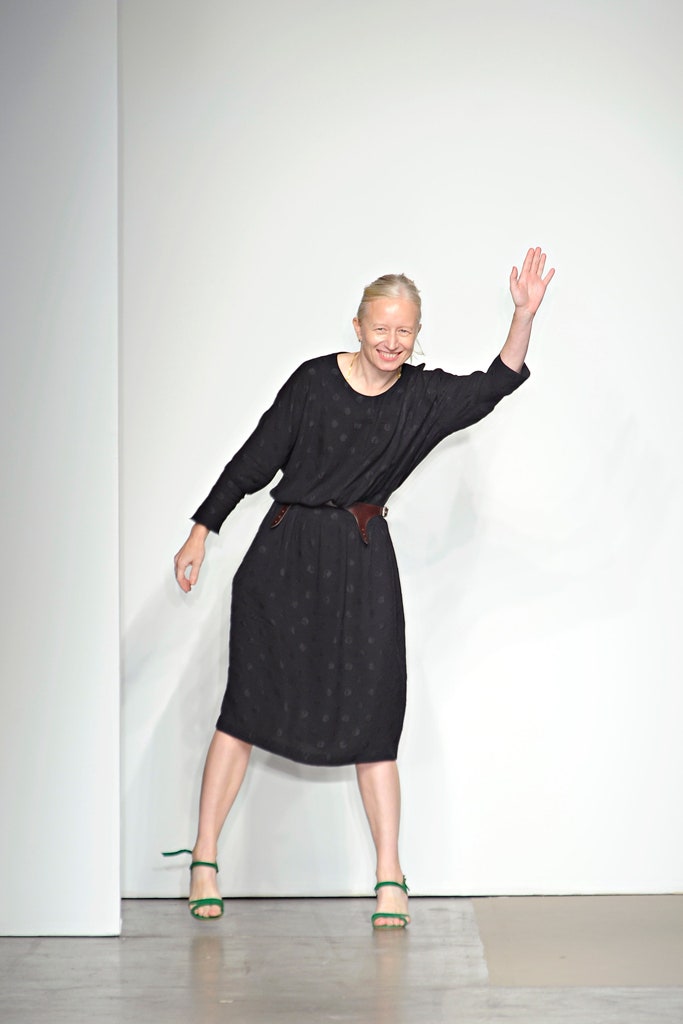 A relaxed black cotton dress with long sleeves and a collared neckline.