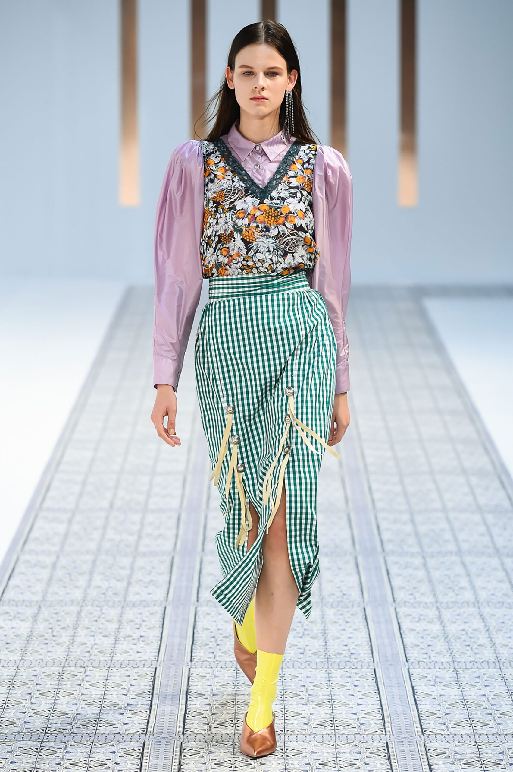 A fitted purple floral top with long sleeves paired with a flared green printed skirt.